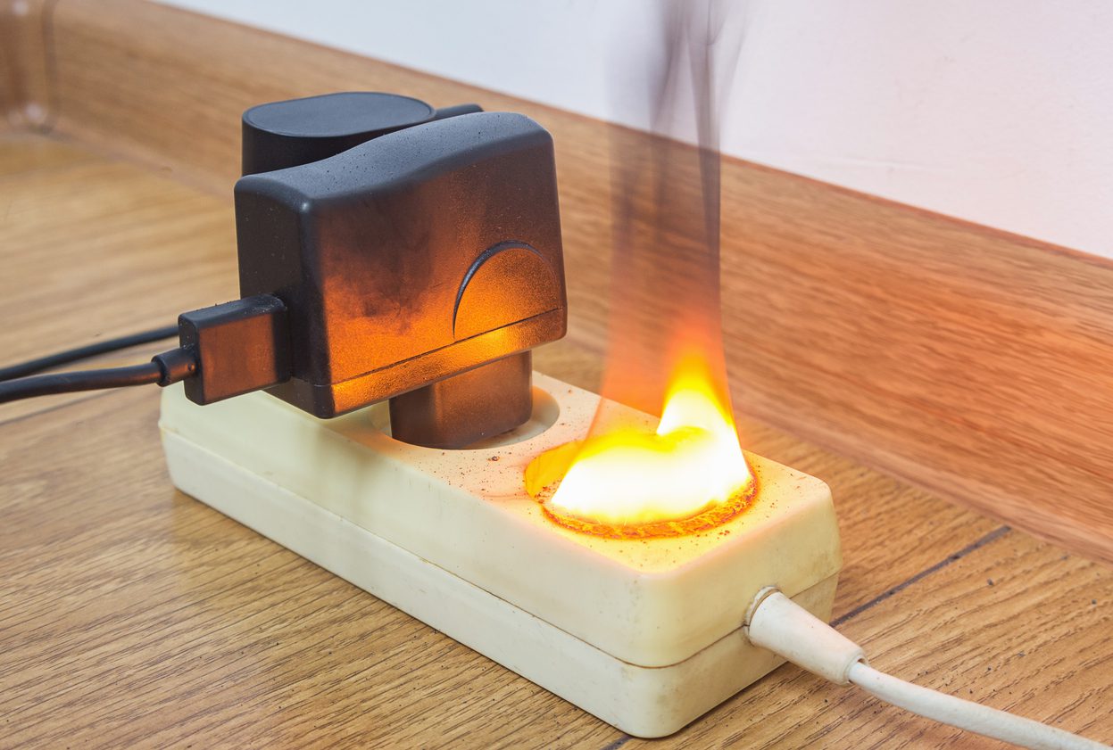 Fire insurance, concept. An electrical outlet that is burnt after short circuit and may cause a fire at home.